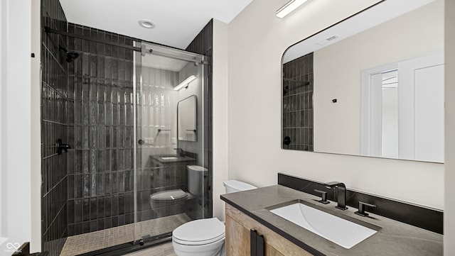 bathroom with vanity, an enclosed shower, and toilet