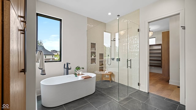 bathroom featuring plus walk in shower and hardwood / wood-style flooring