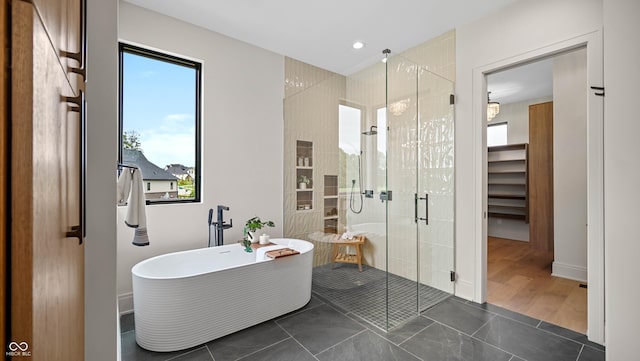 full bath featuring recessed lighting, a freestanding bath, a shower stall, and tile patterned floors