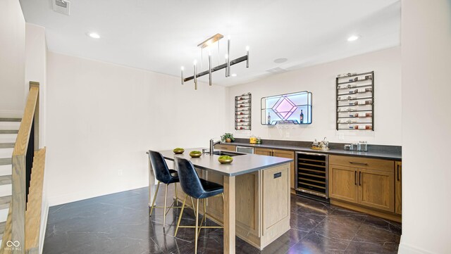 bar with beverage cooler, sink, and decorative light fixtures