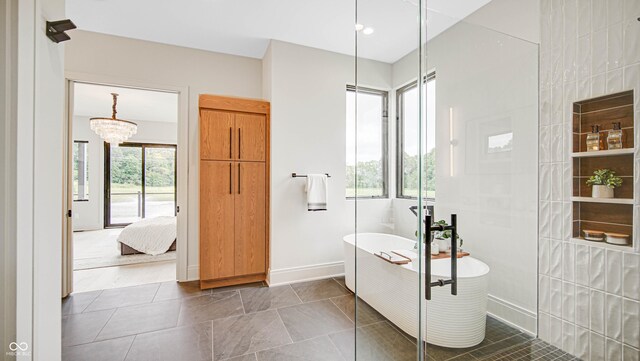 bathroom featuring separate shower and tub, plenty of natural light, and an inviting chandelier