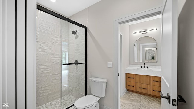 bathroom featuring toilet, a stall shower, baseboards, and vanity