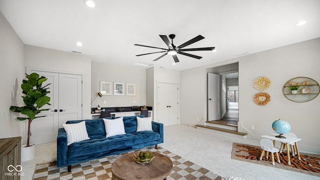 living area featuring recessed lighting, visible vents, a ceiling fan, and light colored carpet