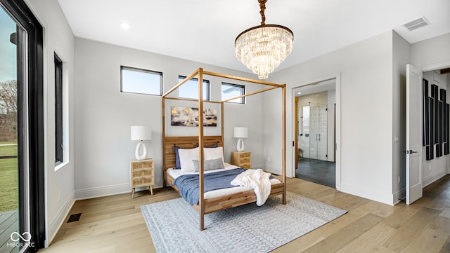 bedroom with a chandelier and light wood-type flooring