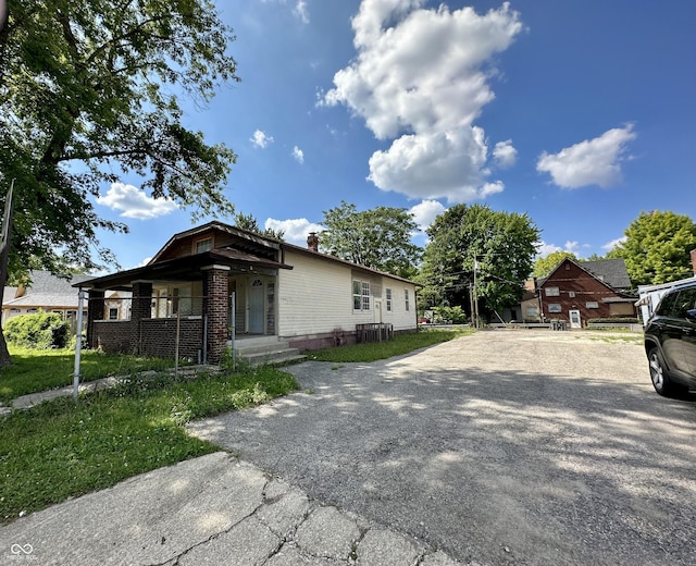2716 E New York St, Indianapolis, IN 46201 - view of front of home featuring a chimney, driveway, and brick siding