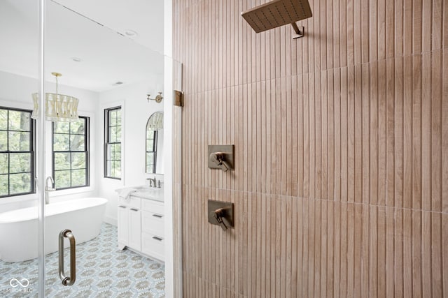 bathroom with vanity, a bath, and a chandelier