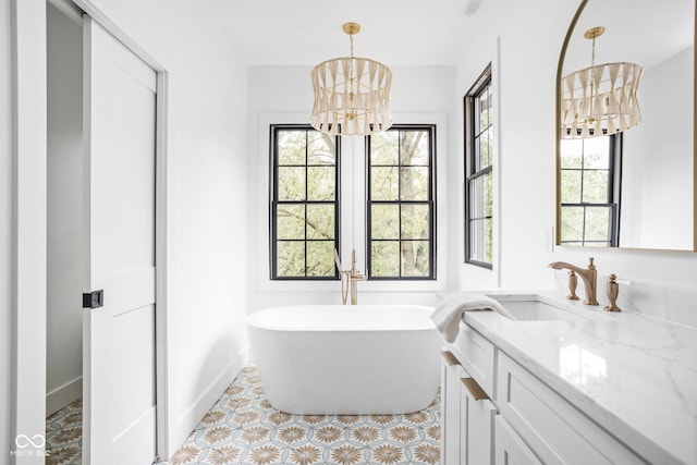 bathroom featuring a tub, a chandelier, and vanity