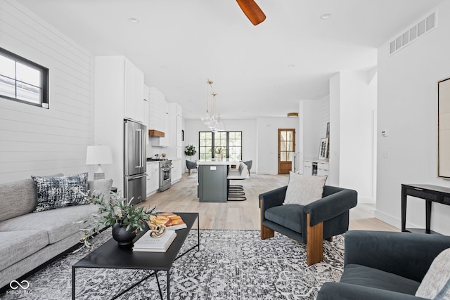 living room featuring light wood-type flooring and ceiling fan