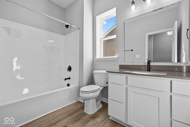 full bathroom featuring wood-type flooring, toilet, bathtub / shower combination, and vanity