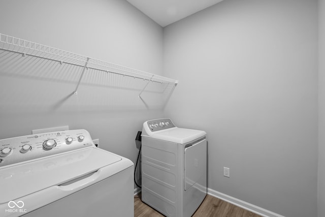 clothes washing area featuring dark hardwood / wood-style flooring and washer and clothes dryer