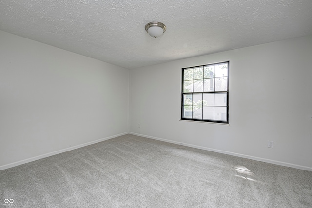 carpeted spare room with a textured ceiling