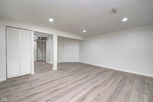 basement with light hardwood / wood-style flooring