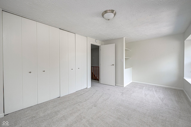 unfurnished bedroom with light carpet and a textured ceiling