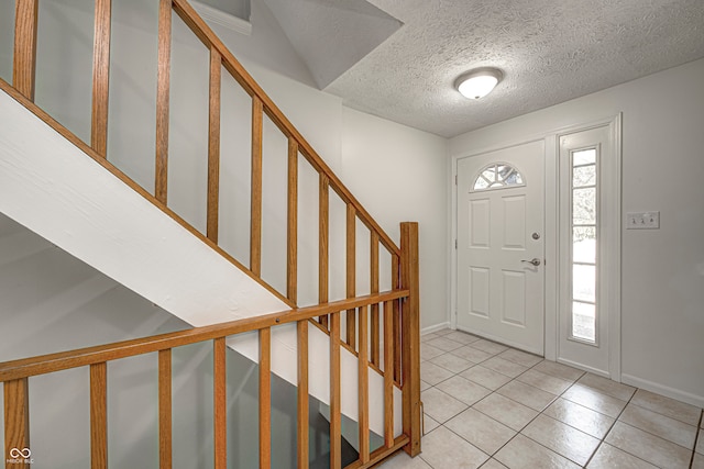 tiled entryway featuring a textured ceiling