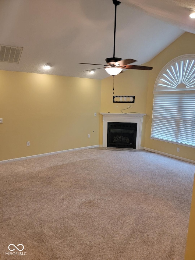 unfurnished living room featuring lofted ceiling, ceiling fan, and carpet flooring