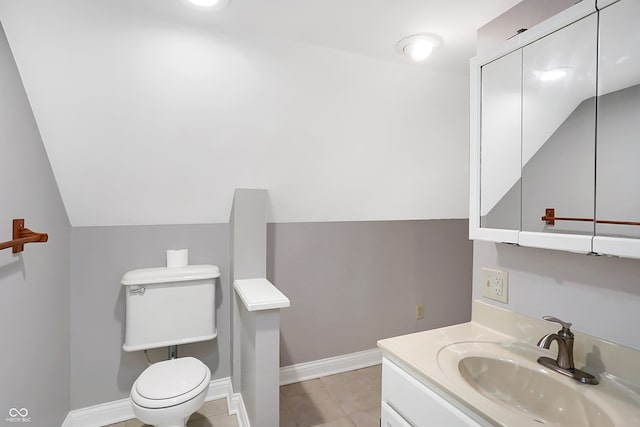 bathroom with lofted ceiling, vanity, toilet, and tile patterned flooring