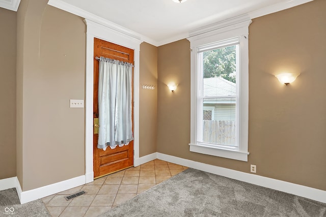 tiled foyer entrance featuring crown molding