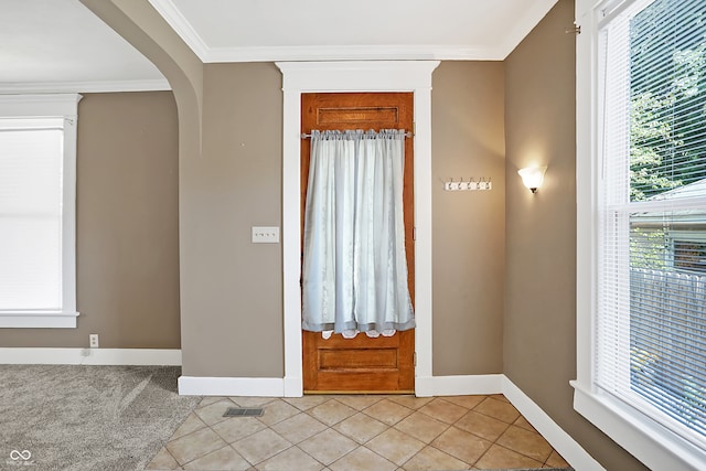 tiled foyer entrance featuring crown molding