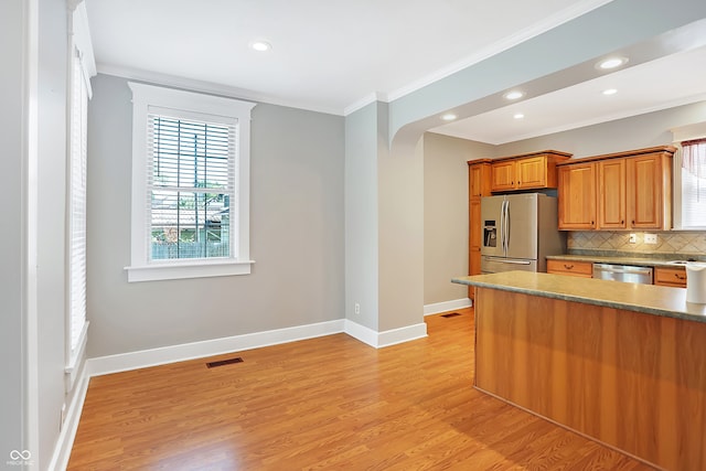 kitchen with ornamental molding, light hardwood / wood-style flooring, stainless steel appliances, and decorative backsplash