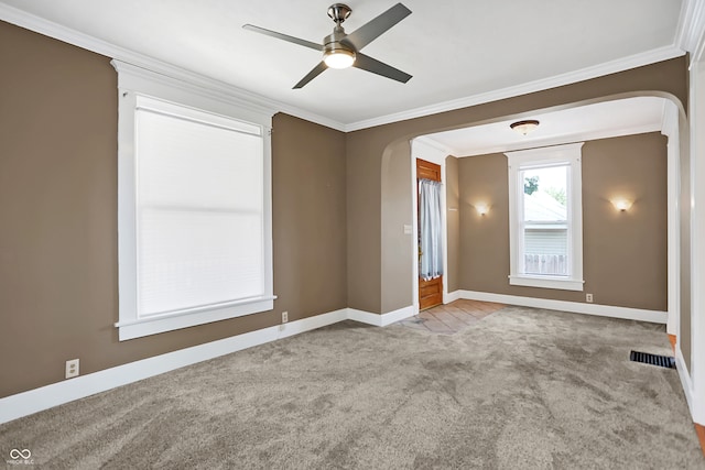 carpeted spare room featuring crown molding and ceiling fan