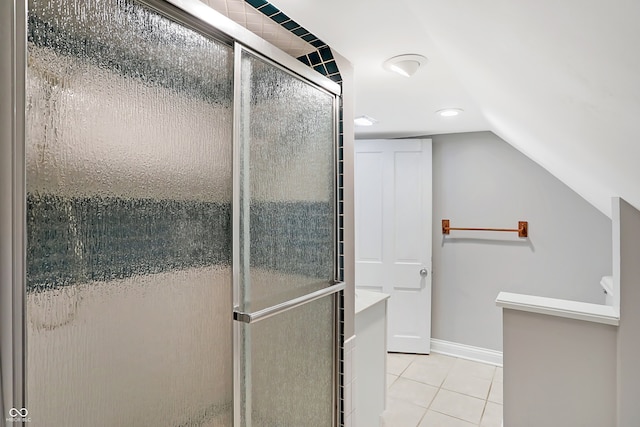 bathroom with lofted ceiling, walk in shower, and tile patterned flooring