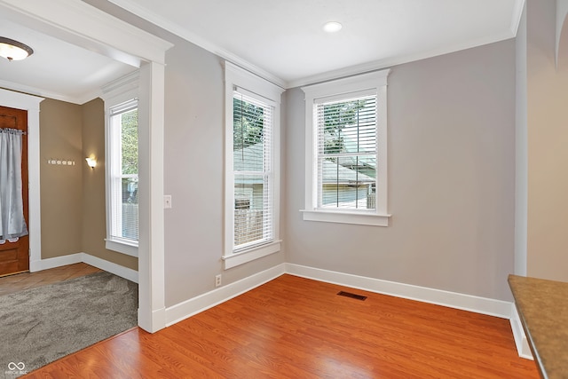 spare room featuring hardwood / wood-style flooring and crown molding