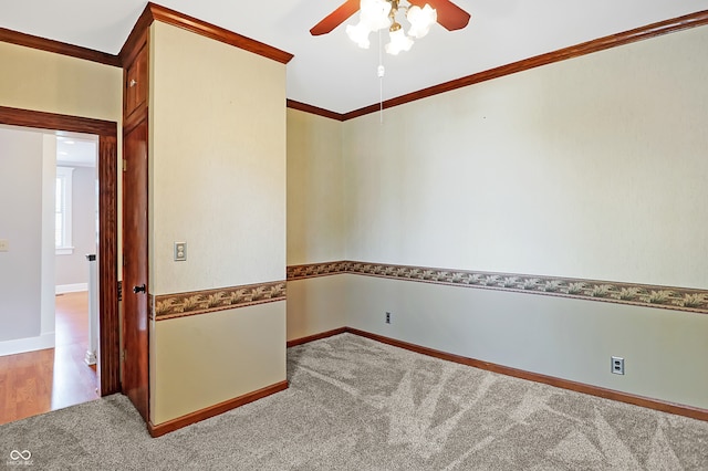 carpeted spare room with ceiling fan and ornamental molding