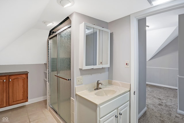 bathroom with tile patterned floors, vaulted ceiling, a shower with door, and vanity