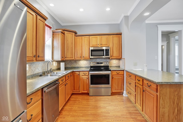 kitchen with backsplash, sink, appliances with stainless steel finishes, and light hardwood / wood-style floors