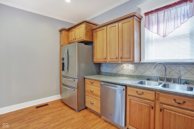 kitchen featuring light hardwood / wood-style flooring, backsplash, crown molding, stainless steel appliances, and sink