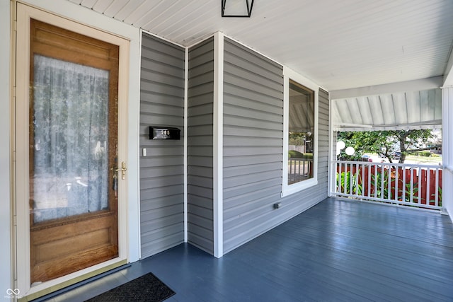 view of exterior entry featuring covered porch