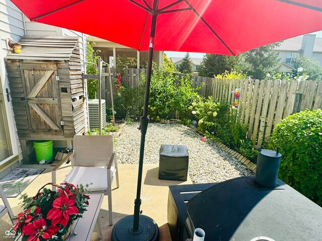 view of patio / terrace featuring a shed and central air condition unit