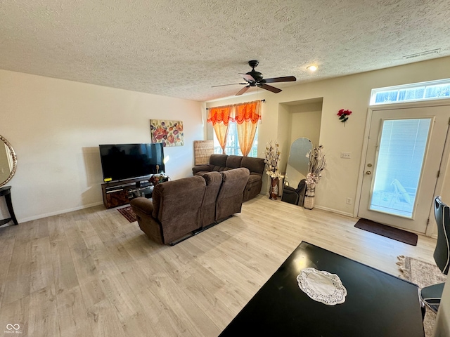 living room featuring a textured ceiling, a healthy amount of sunlight, ceiling fan, and light hardwood / wood-style flooring