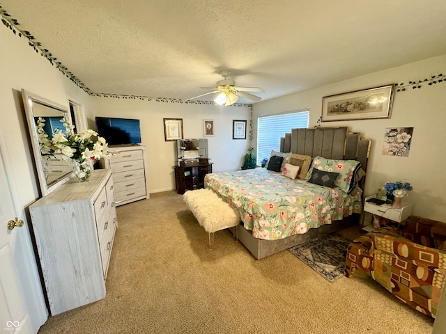 carpeted bedroom featuring ceiling fan and a textured ceiling