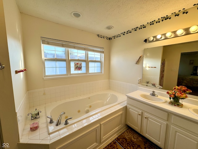 bathroom featuring vanity, a textured ceiling, and a tub