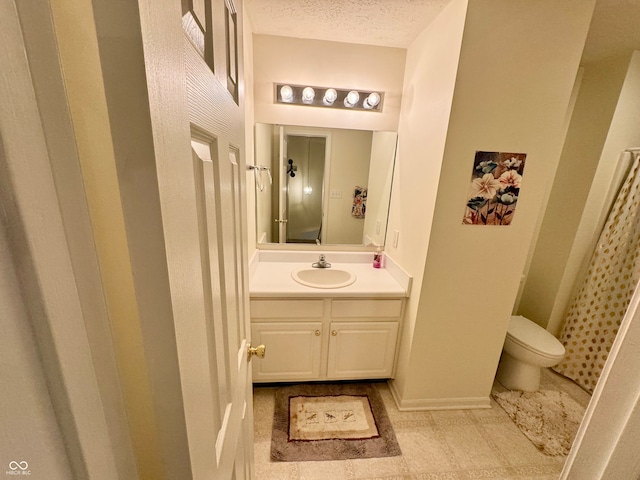 bathroom featuring a textured ceiling, vanity, and toilet