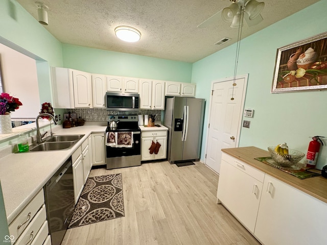 kitchen with decorative backsplash, white cabinets, appliances with stainless steel finishes, and sink