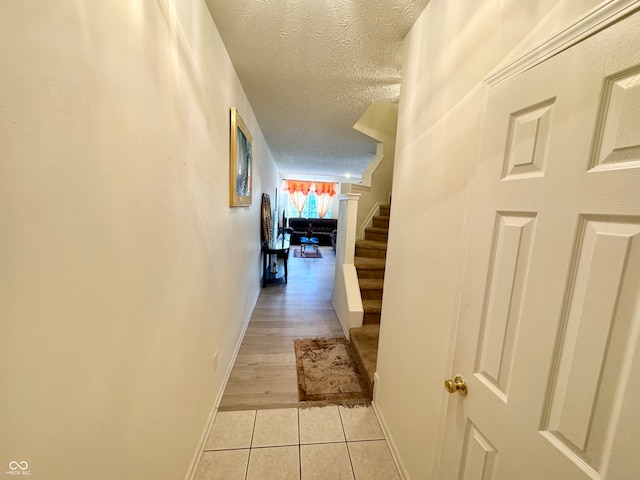 hallway featuring a textured ceiling and light wood-type flooring