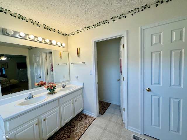 bathroom featuring vanity, a textured ceiling, and ceiling fan