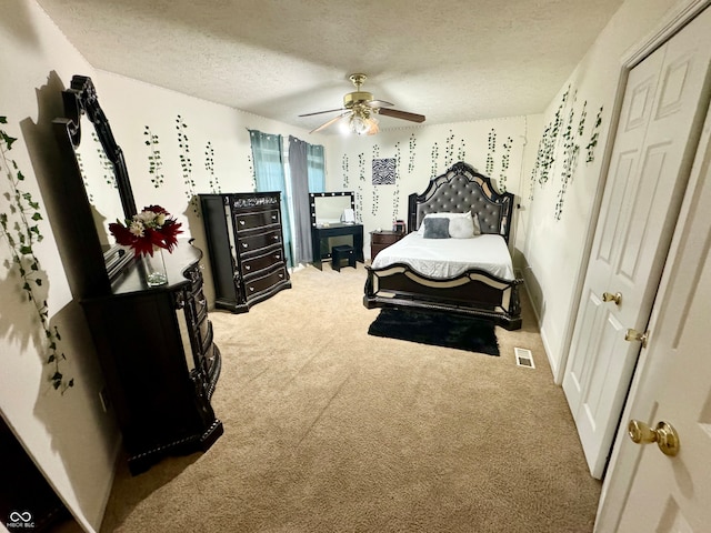 bedroom featuring ceiling fan, a textured ceiling, and carpet