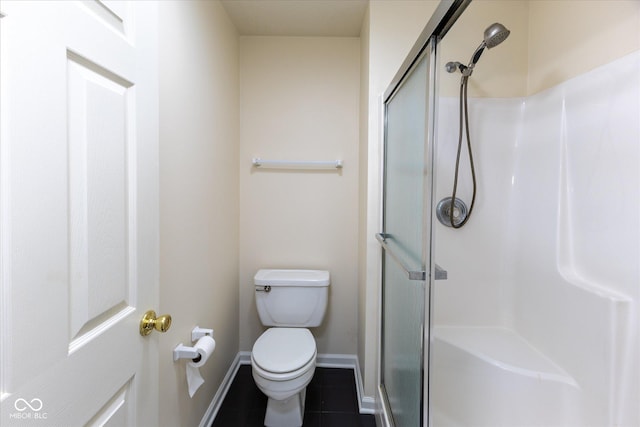 full bath with tile patterned flooring, a stall shower, toilet, and baseboards