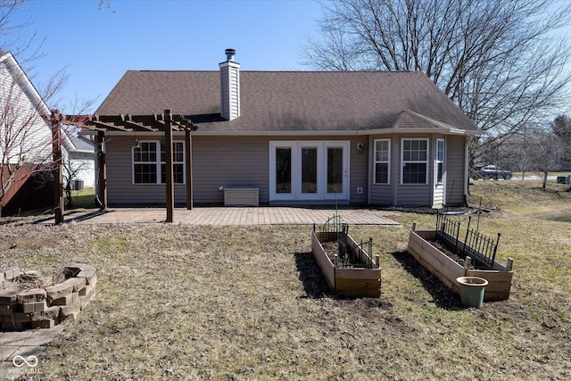 back of property with roof with shingles, french doors, a garden, a patio area, and a pergola