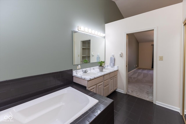 bathroom featuring lofted ceiling, a bath, baseboards, and a sink