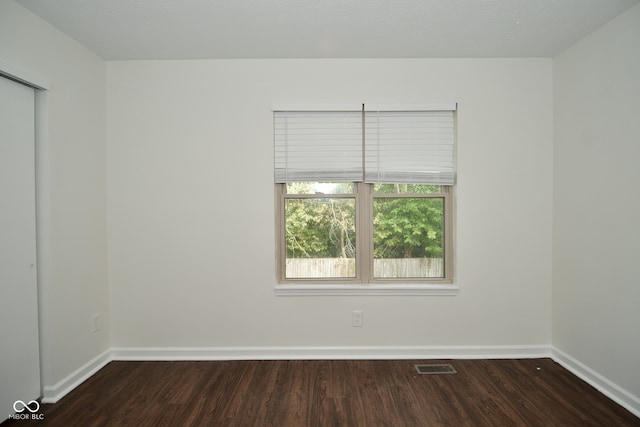 spare room with dark hardwood / wood-style flooring