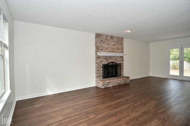 unfurnished living room with a textured ceiling, a fireplace, and dark hardwood / wood-style flooring