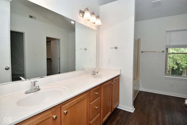 bathroom with wood-type flooring, vaulted ceiling, and vanity