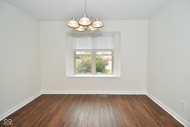 unfurnished room with a notable chandelier and dark hardwood / wood-style flooring