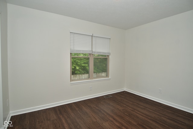 empty room featuring a textured ceiling and hardwood / wood-style floors