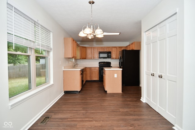 kitchen with a kitchen island, black appliances, an inviting chandelier, decorative light fixtures, and dark hardwood / wood-style floors