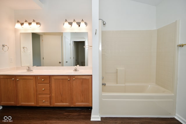 bathroom featuring wood-type flooring, vanity, and shower / bathing tub combination